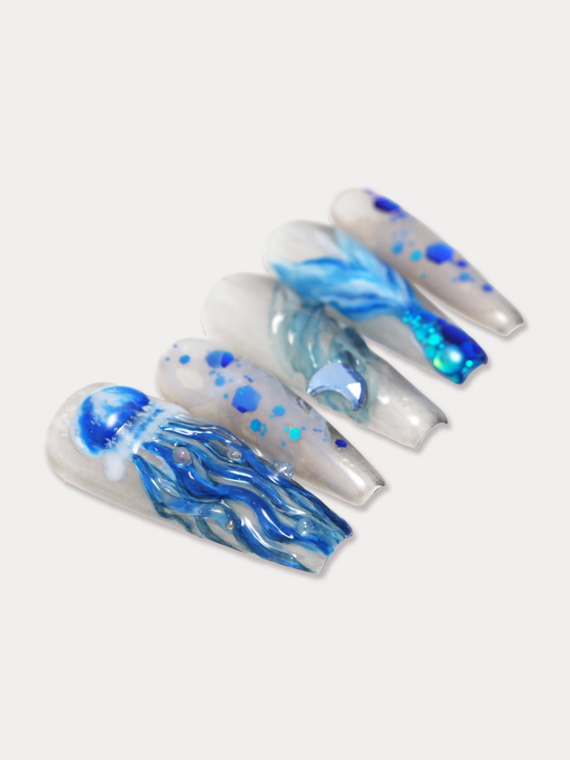 MIEAP 3D Jellyfish press on nail set features handcrafted 3D jellyfish and mermaid tail designs. The nails are embellished with unique blue glitter, creating a shimmering effect reminiscent of the sparkling ocean under sunlight. #MIEAP #MIEAPnails #pressonnail #falsenail #acrylicnail #nails #nailart #naildesign #nailinspo #handmadenail #summernail #nail2023 #graduationnail #luxurynail #longnail #coffinnail #3Dnail #datingnail #promnail